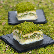 Green dessert on a black slate plate with a blurred background