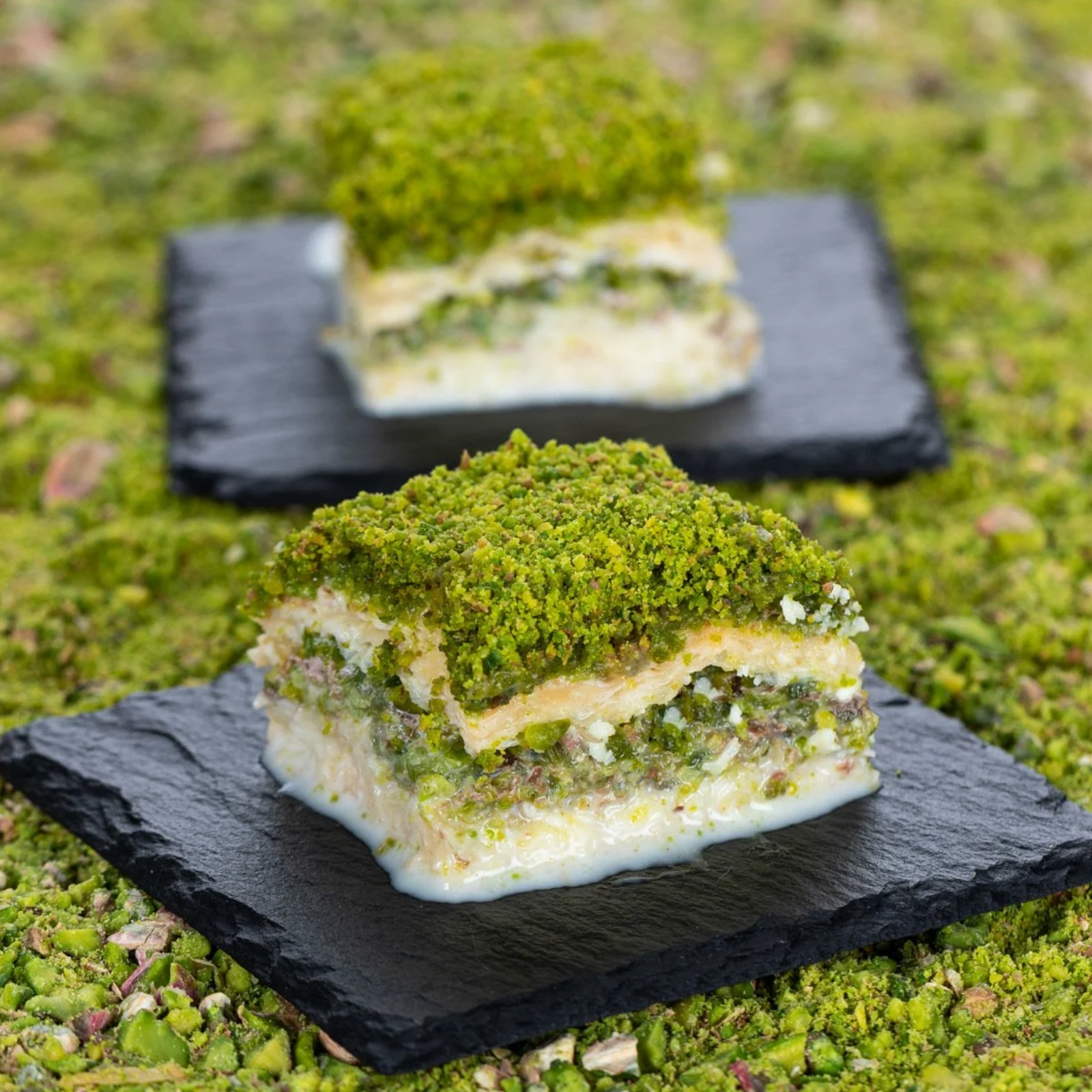 Green dessert on a black slate plate with a blurred background